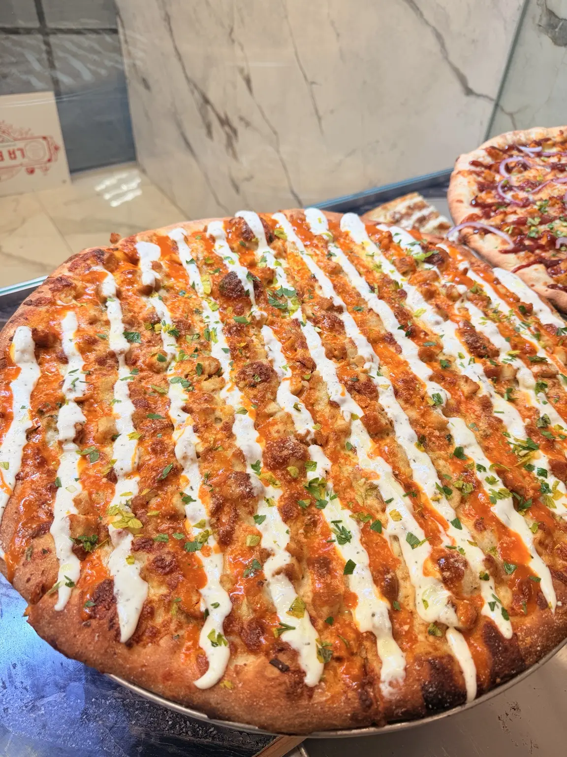 Full Buffalo chicken pizza with creamy ranch drizzle
