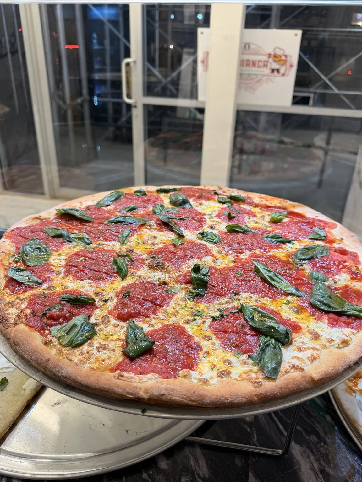 A full New York pizza with tomato, cheese, and basil
