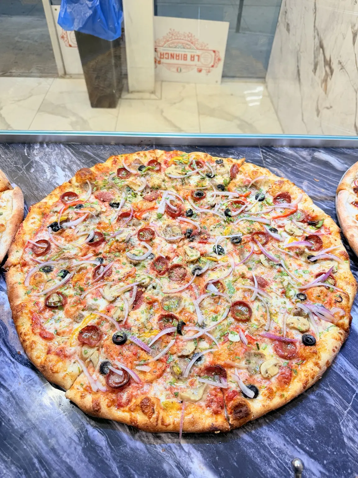 Vegetable pizza with mushrooms, olives, peppers, and onions
