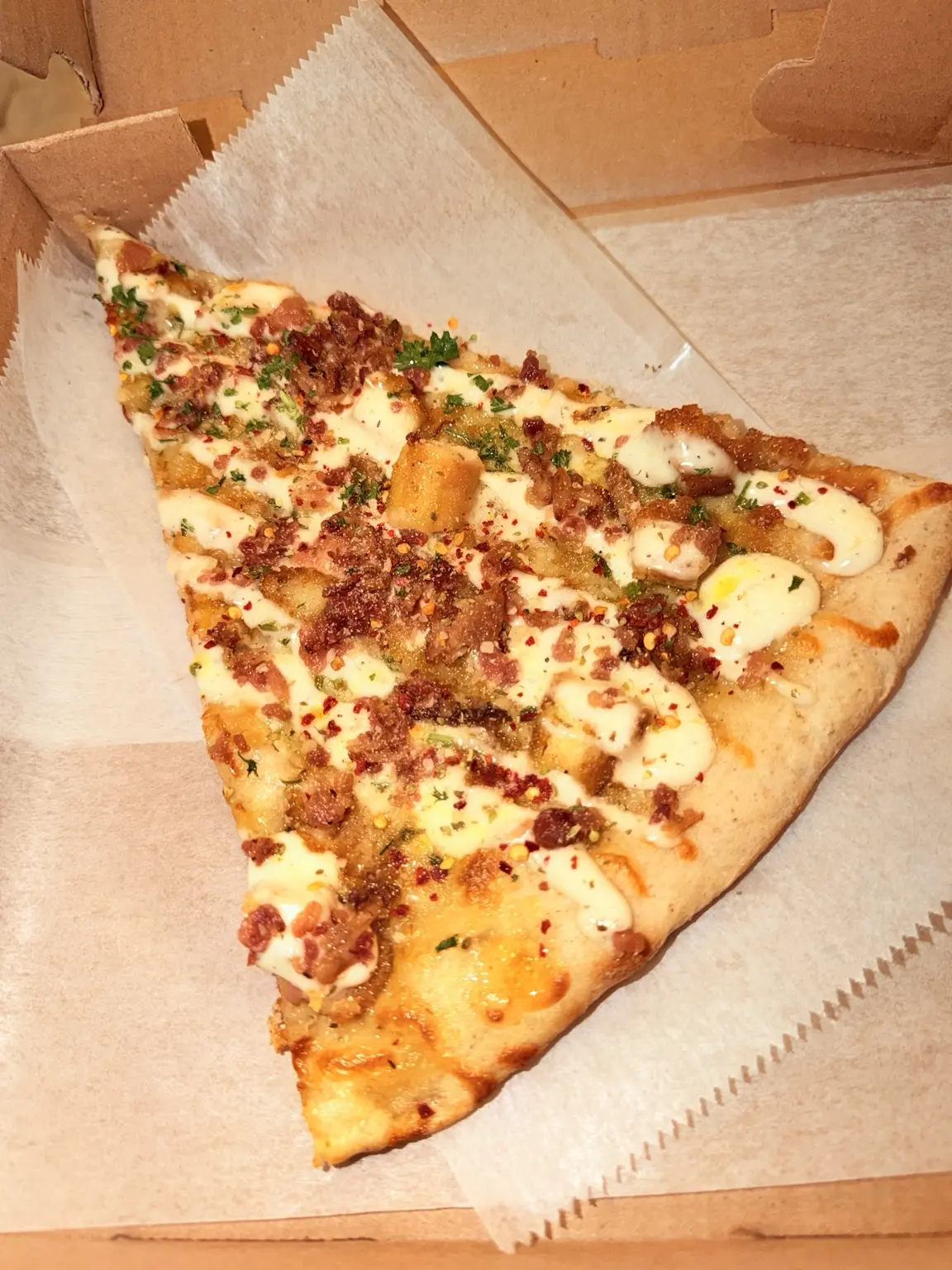 A chicken bacon ranch slice in a pizza box