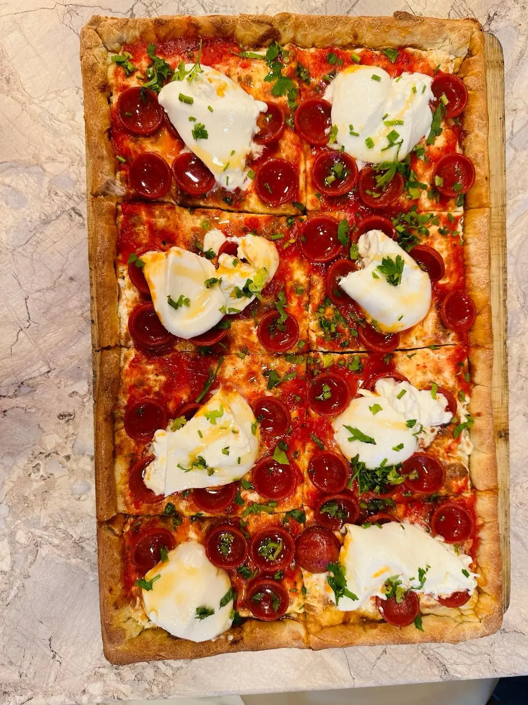 A square pepperoni pizza finished with creamy burrata