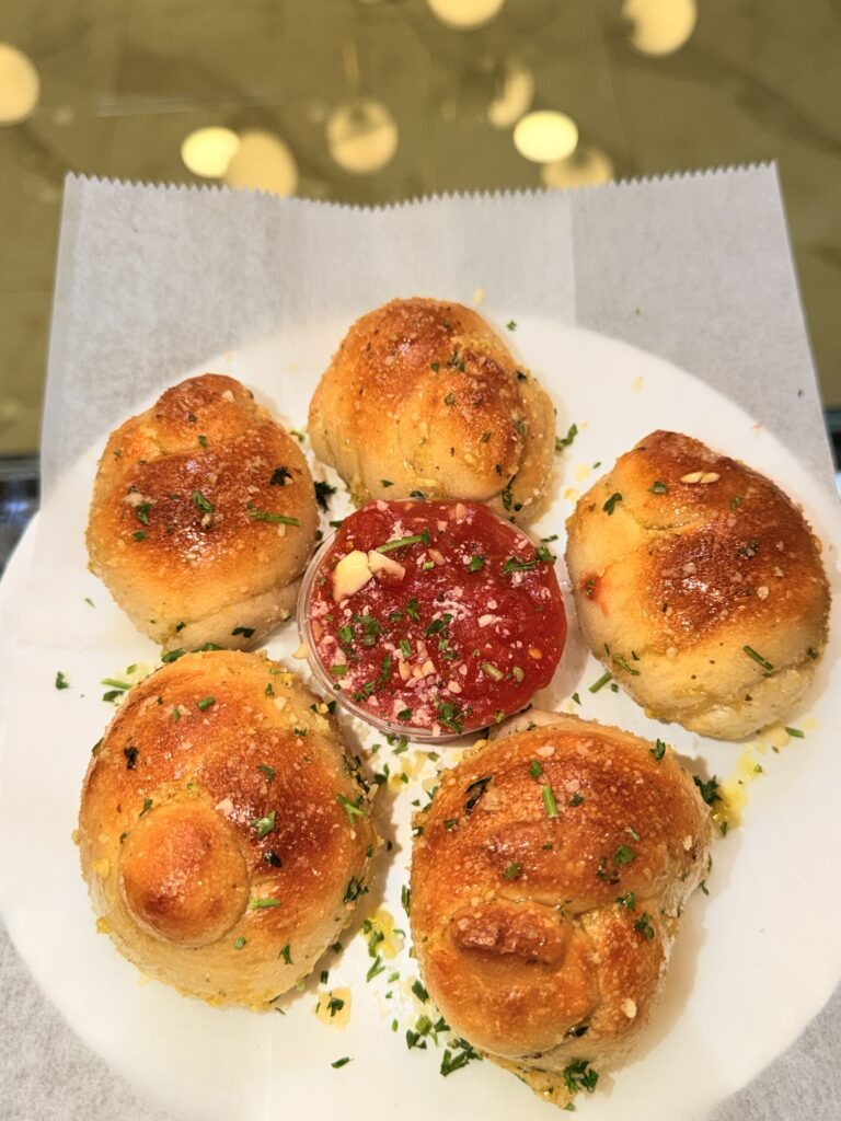 Golden garlic knots served with marinara sauce at La Bianca Pizza