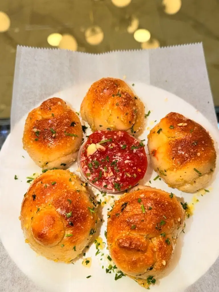 Golden garlic knots served with marinara sauce at La Bianca Pizza