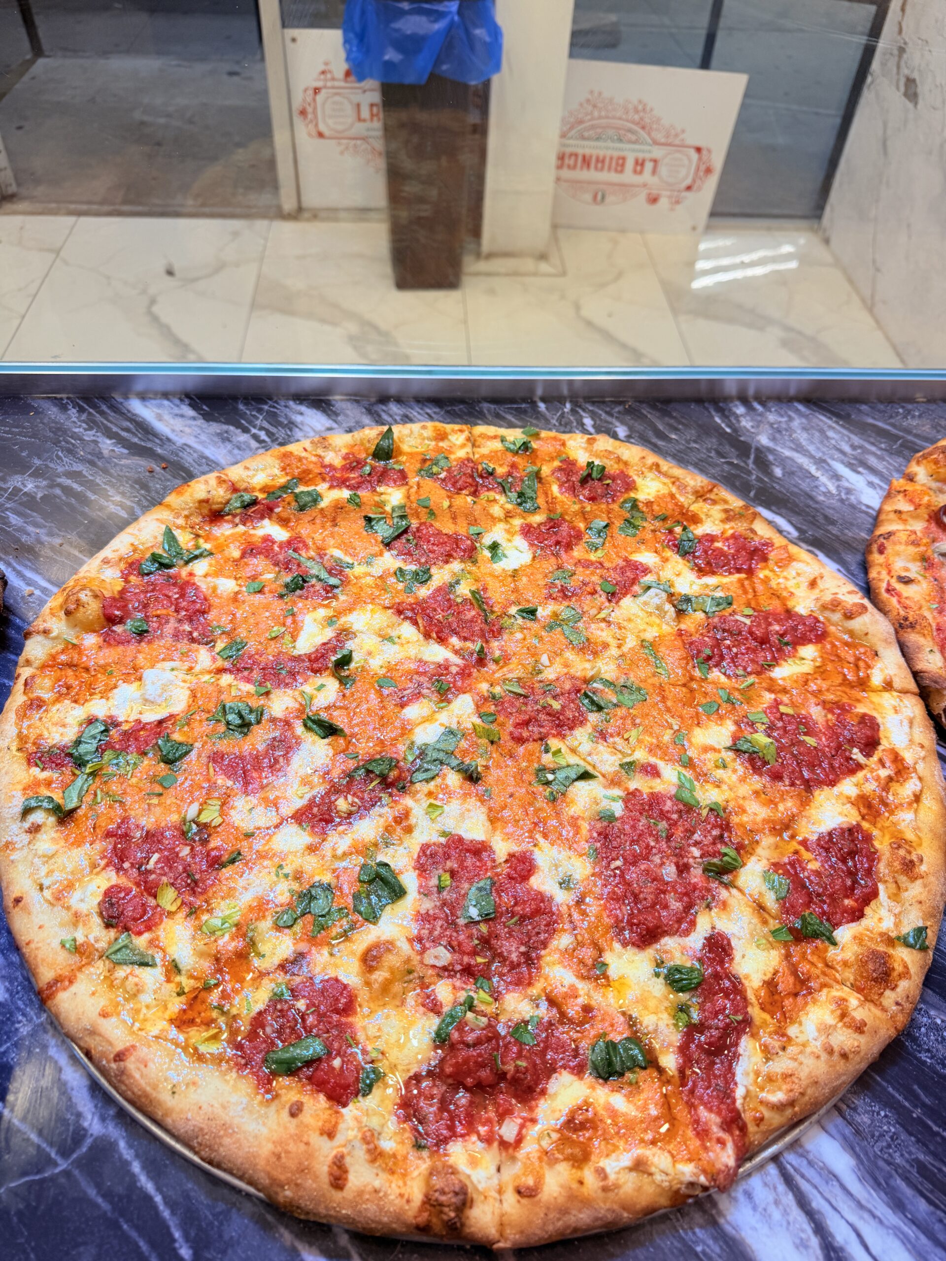 Whole Margherita pizza with tomato, mozzarella, and basil at La Bianca Pizza