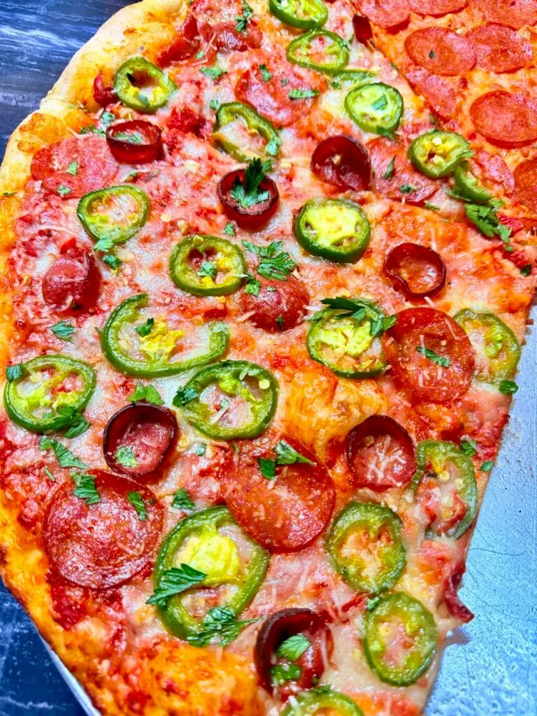 Pepperoni pizza topped with sliced jalapeños and parsley at La Bianca Pizza