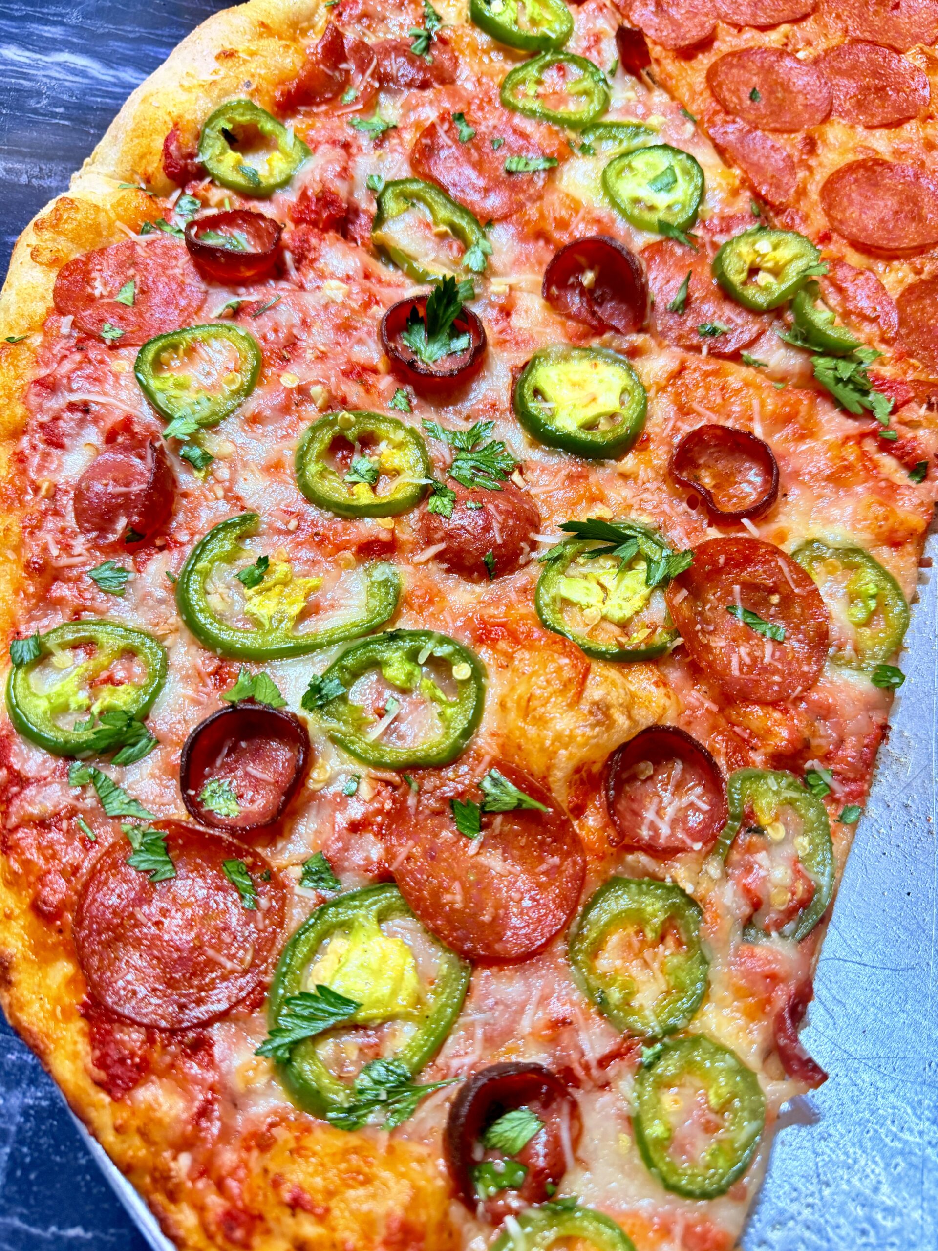Pepperoni pizza topped with sliced jalapeños and parsley at La Bianca Pizza