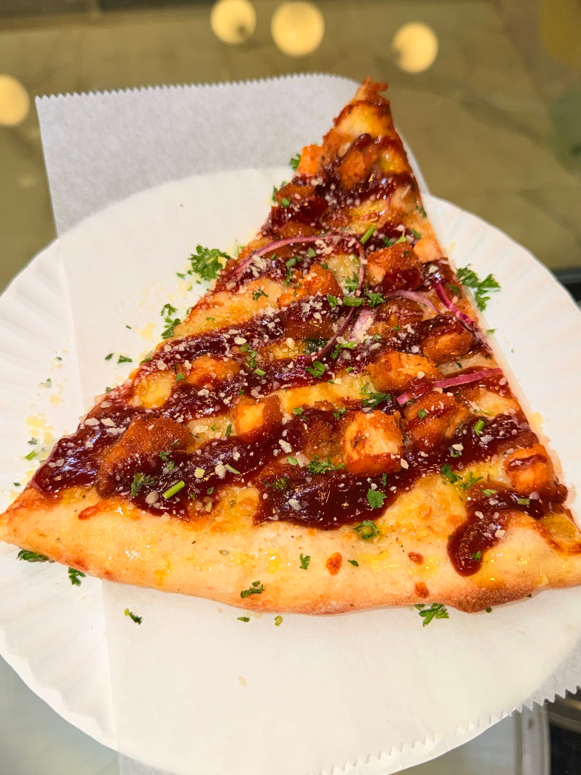 BBQ chicken pizza slice with red onion and herbs at La Bianca Pizza on West 14th Street